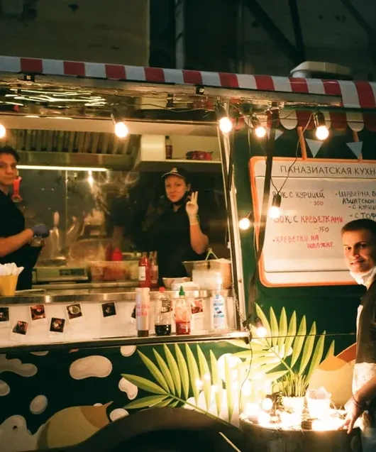 Customers ordering at the window of a food truck