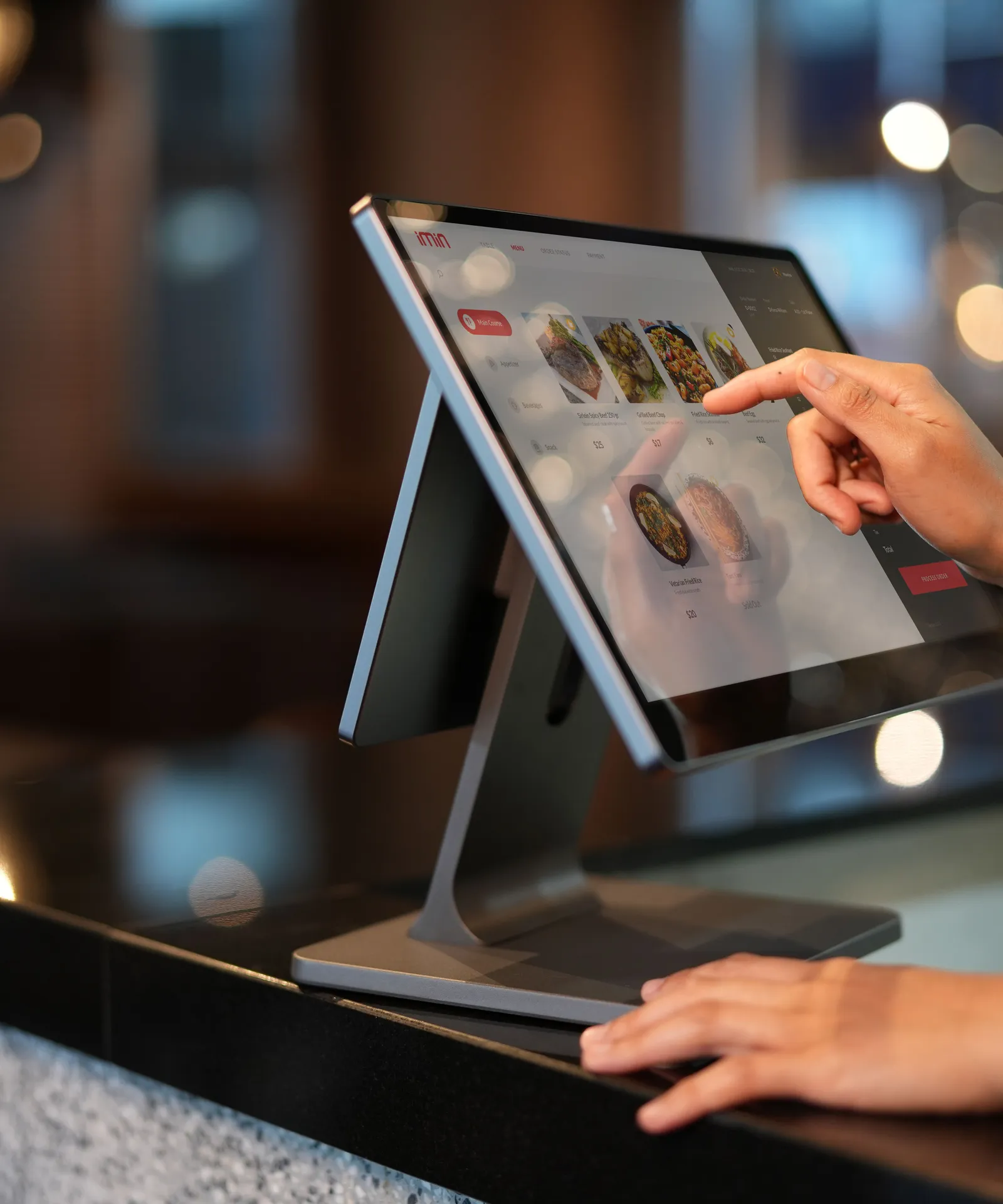A server ringing up an order on a countertop tablet